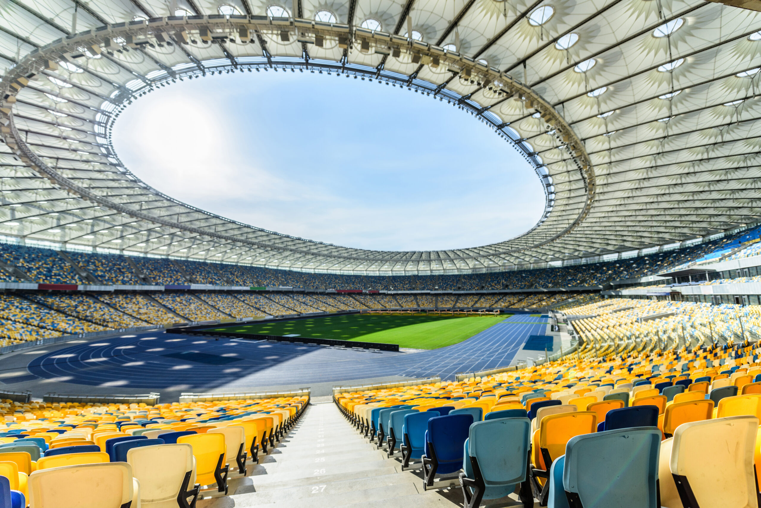 rows of yellow and blue stadium seats on soccer field stadium